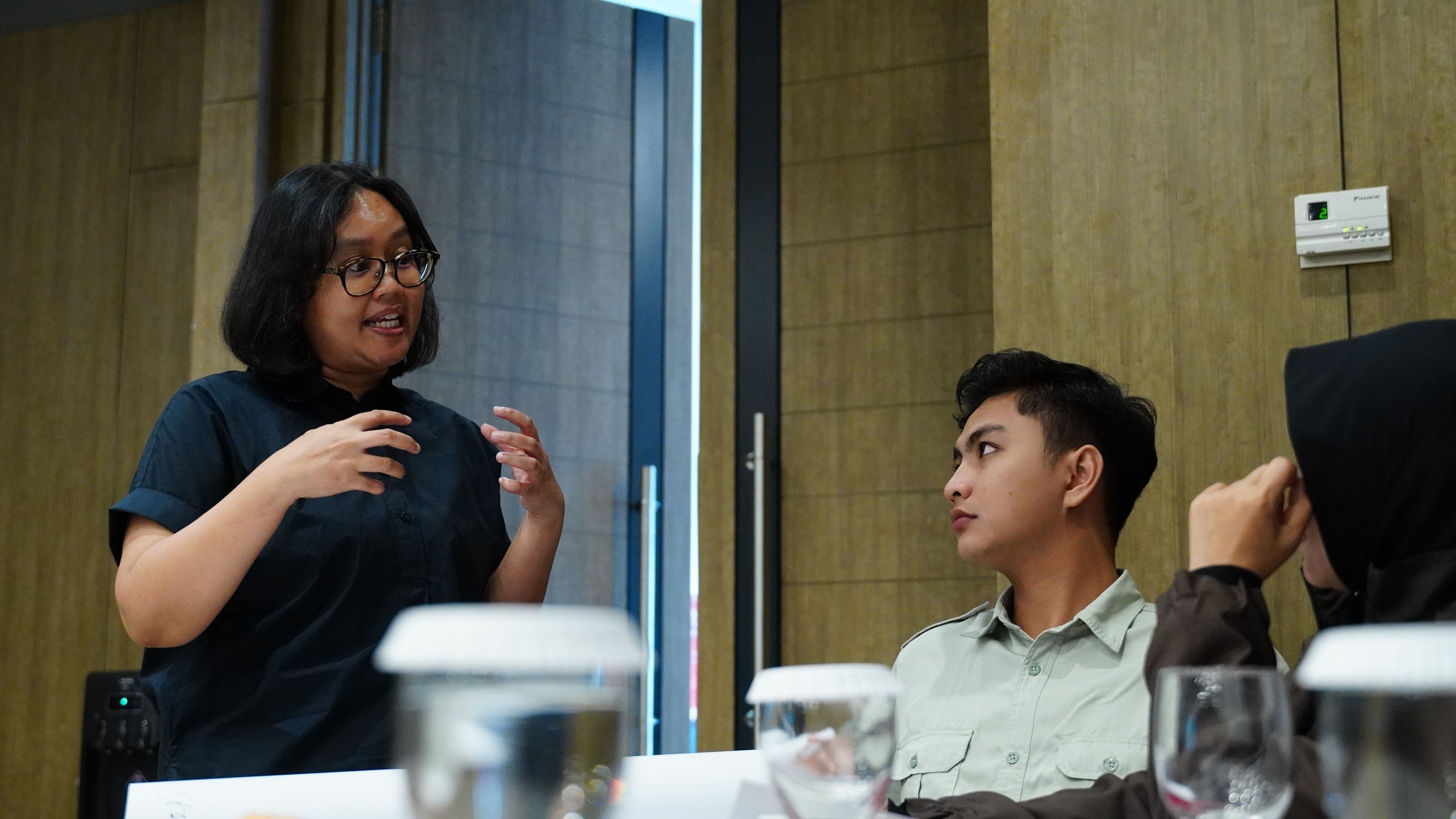 Participants comparing notes pinned to wall